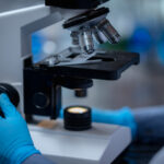 Young scientist looking through a microscope in a laboratory. Young scientist doing some research.